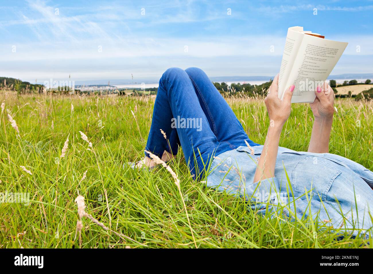Woman lying down and relaxing in a grassy field Stock Photo Alamy