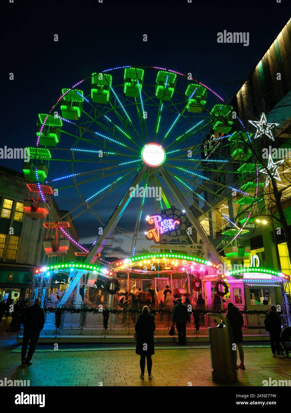 Christmas street market celebrations in Sheffield with the Big Wheel colorfully illuminated at 