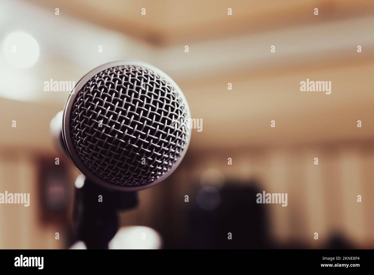 Detail of microphone metallic grid front against defocused background copy space on the right, voice speech singing live music concept Stock Photo