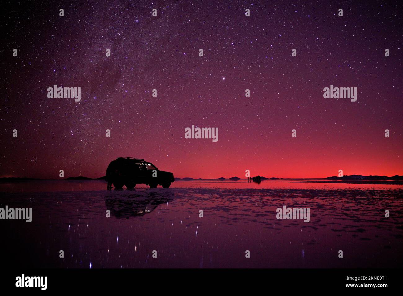 Night star sky at Uyuni salt flats, Bolivia, with a offroad-car parking on the surface. Stock Photo