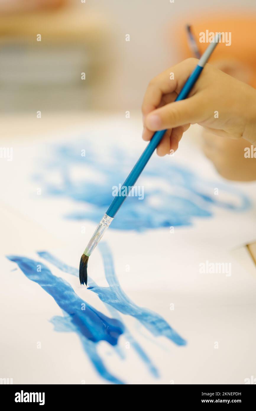 Children painting in kindergarden. Hand of little girl hold brush and paint Stock Photo