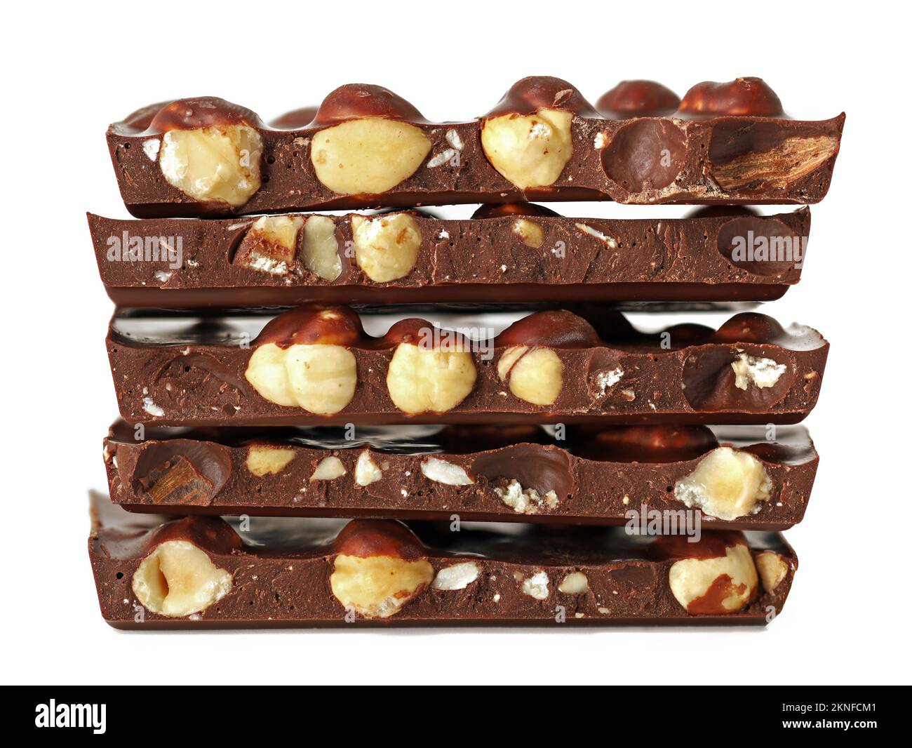 stack of broken chocolate bar with hazelnuts isolated on white
