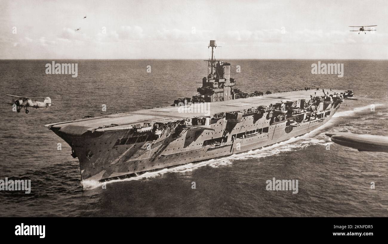 HMS Ark Royal (91), seen here exercising with her aircraft - the machine on the left having just taken off.  From British Warships of the Royal Navy, published 1940. Stock Photo