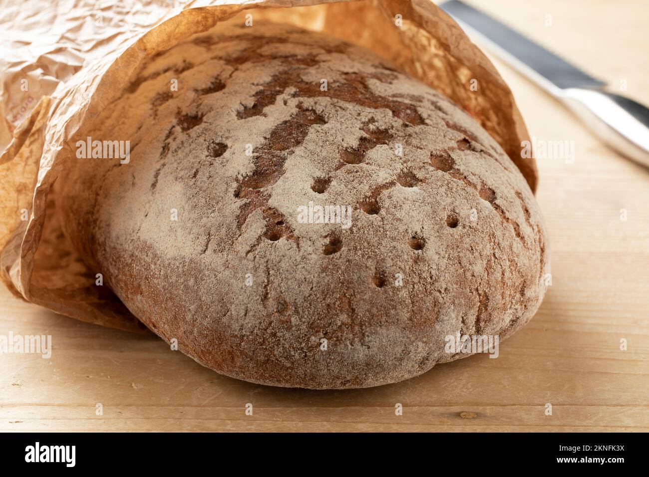Whole German sourdough loaf of bread in a paper bag close up Stock Photo