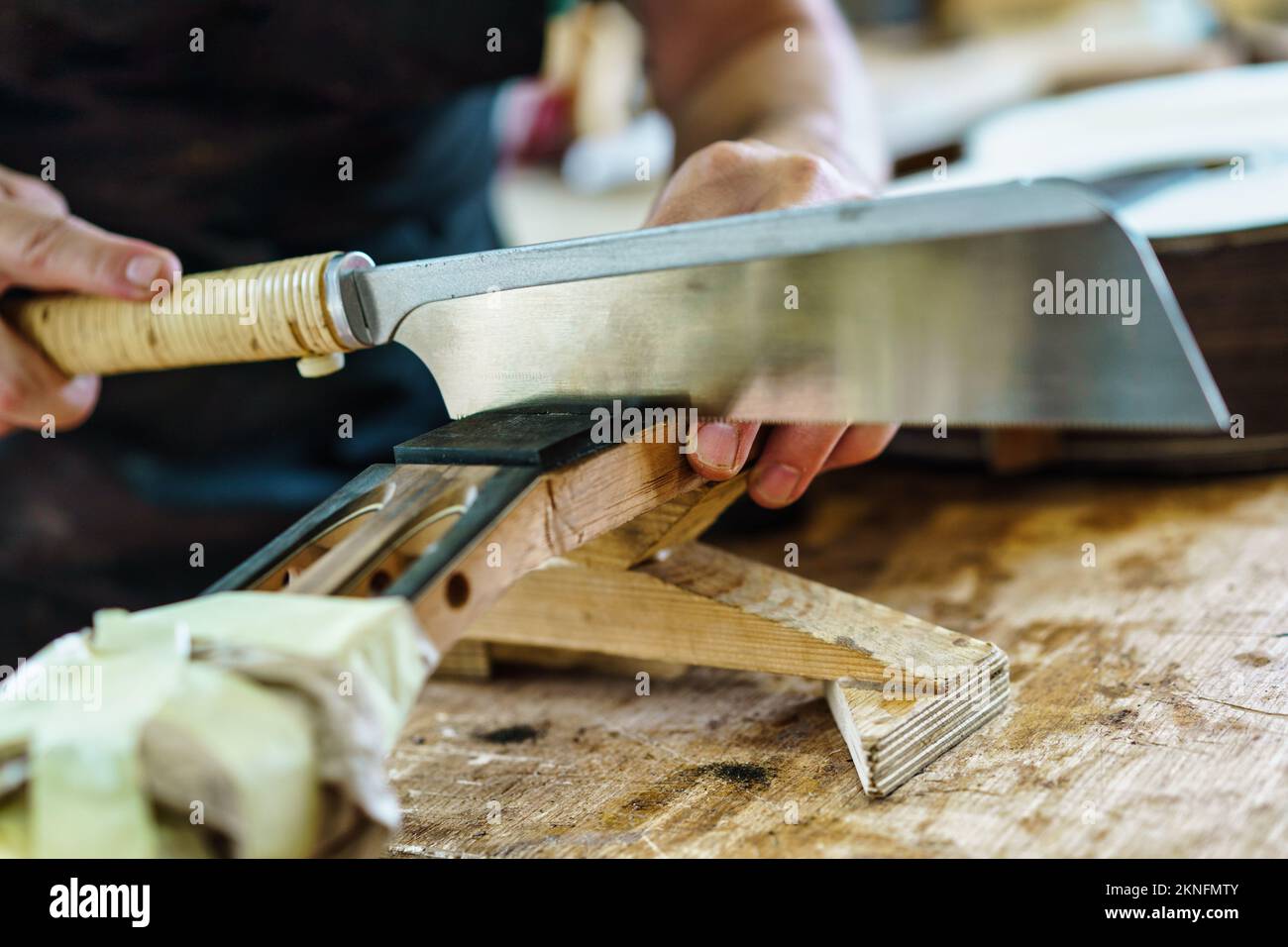 Spanish guitar maker marking the frets on the neck of a flamenco guitar. Stock Photo
