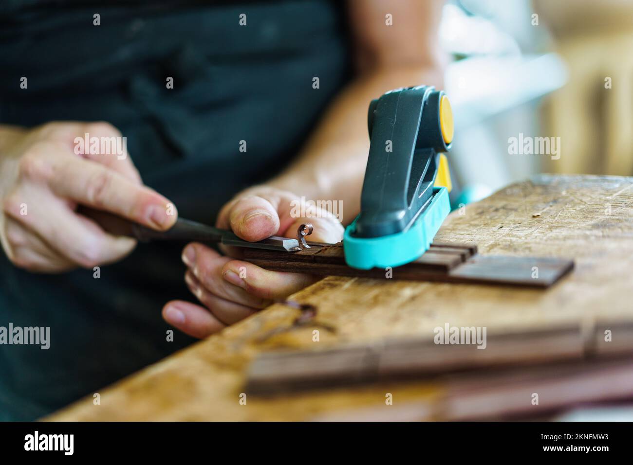 Crop luthier crafting guitar part Stock Photo