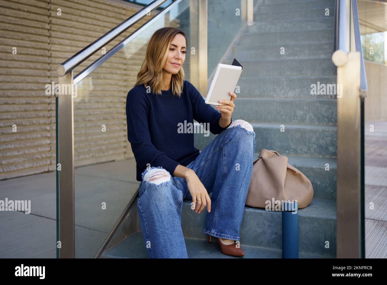 Woman reading e book on steps Stock Photo