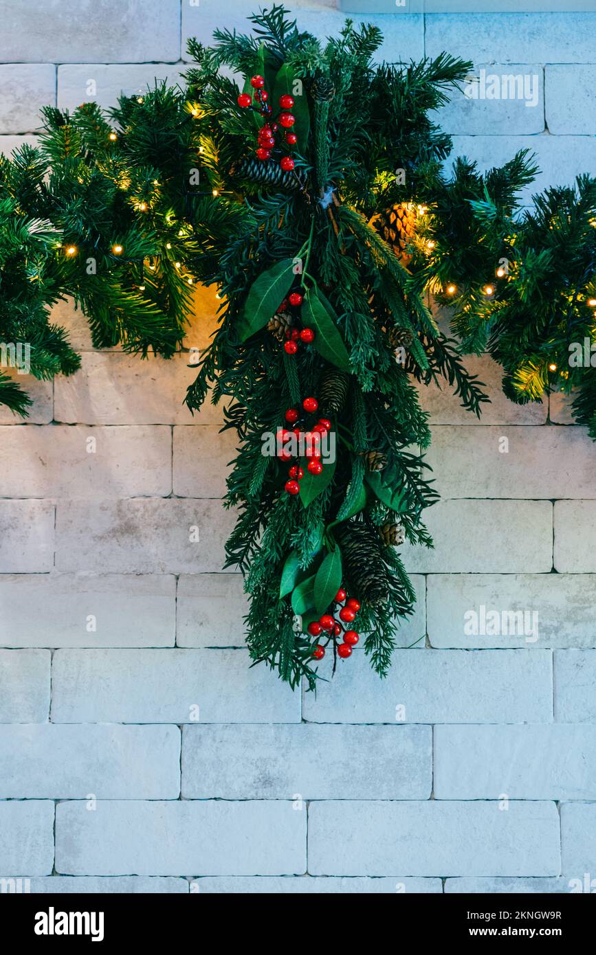 Christmas fir tree with lights on white brick background with copy space Stock Photo