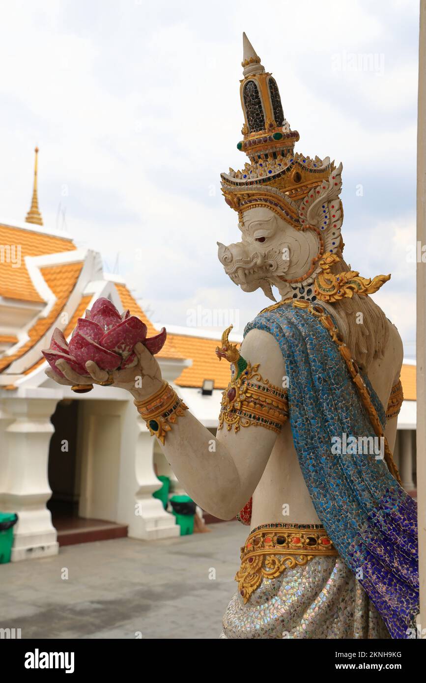 A pearl white statue of Thai mythical goddess holding lotus flower at Wat Pariwat Ratchasongkram. A temple with Thai buddish contemporary art. Stock Photo