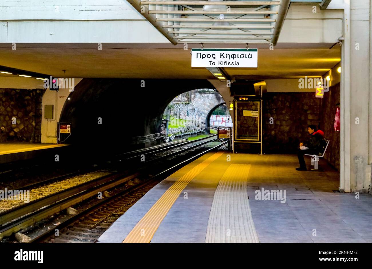 Athens Greece 1 5 2018 Woman waiting at outdoor covered metro station in early morning with a train approaching Stock Photo