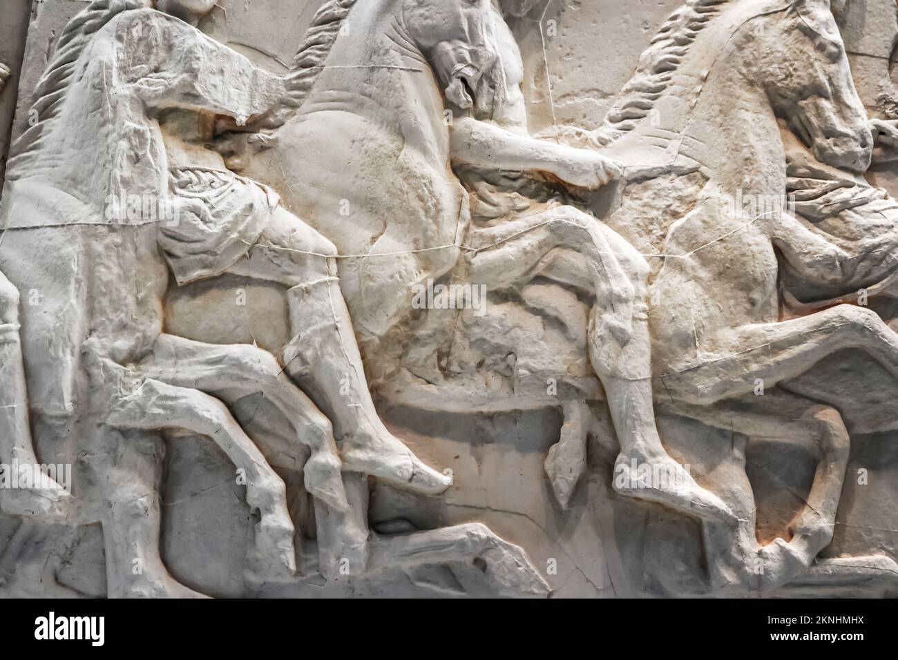 Background of horses in battle - cracked and mended white marble ancient bas relief sculptures from Greece Stock Photo
