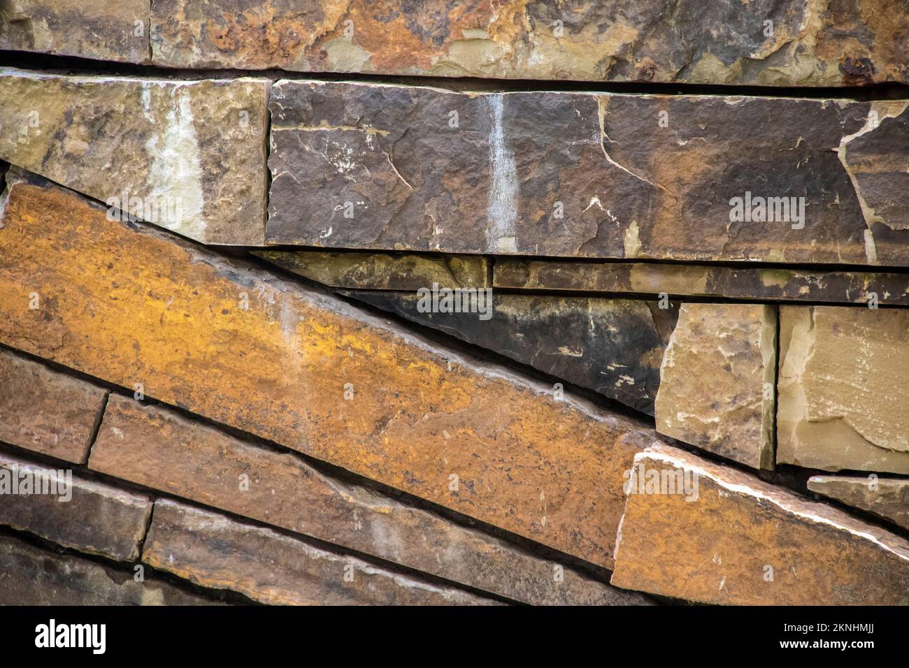 Background of sandstone rocks stacked with some on a diagonal and some horizontal - variety of colors and textures Stock Photo
