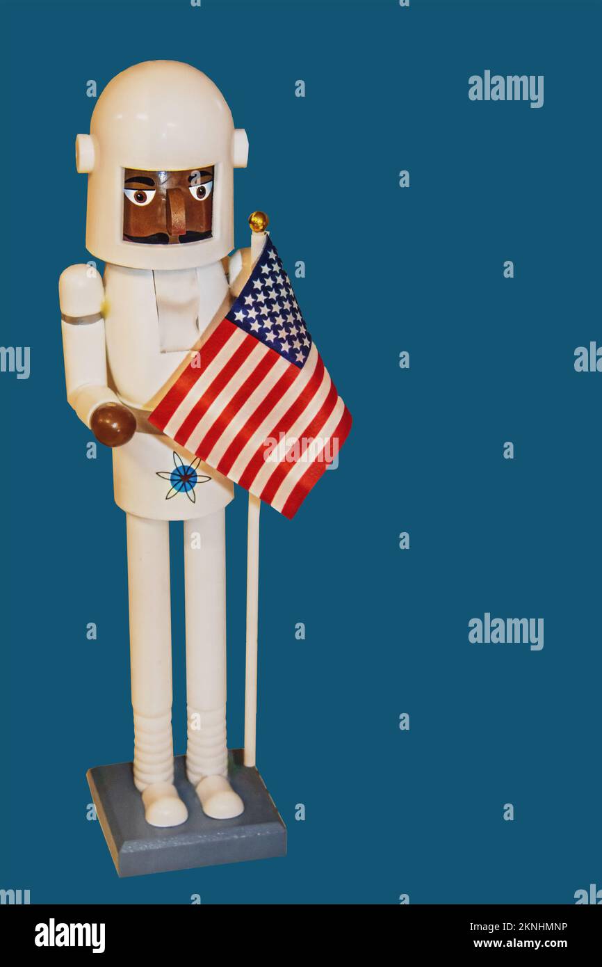 Black Astronaut Christmas Nutcracker figure with American flag isolated on blue- Room for copy Stock Photo