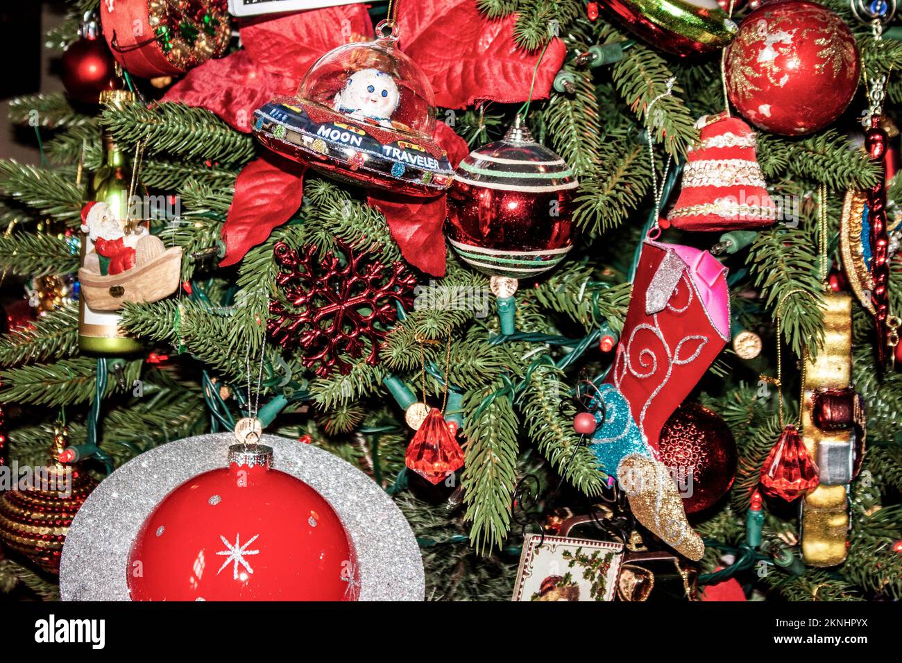 Old fashioned Christmas tree with kitchy outerspace ornaments and cowboy boot and other vintage decorations - Closeup. Stock Photo