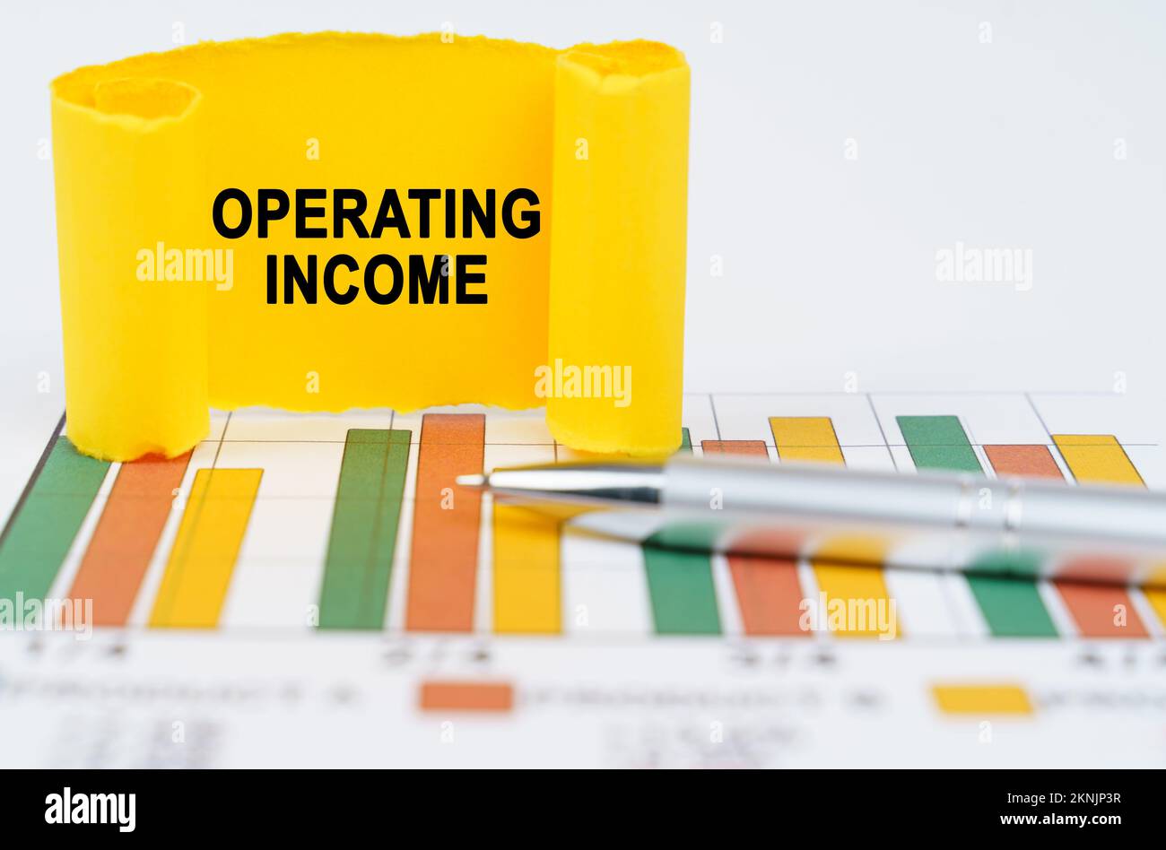 Operating Income Image Business concept. On the business charts are a pen and a paper plate ...