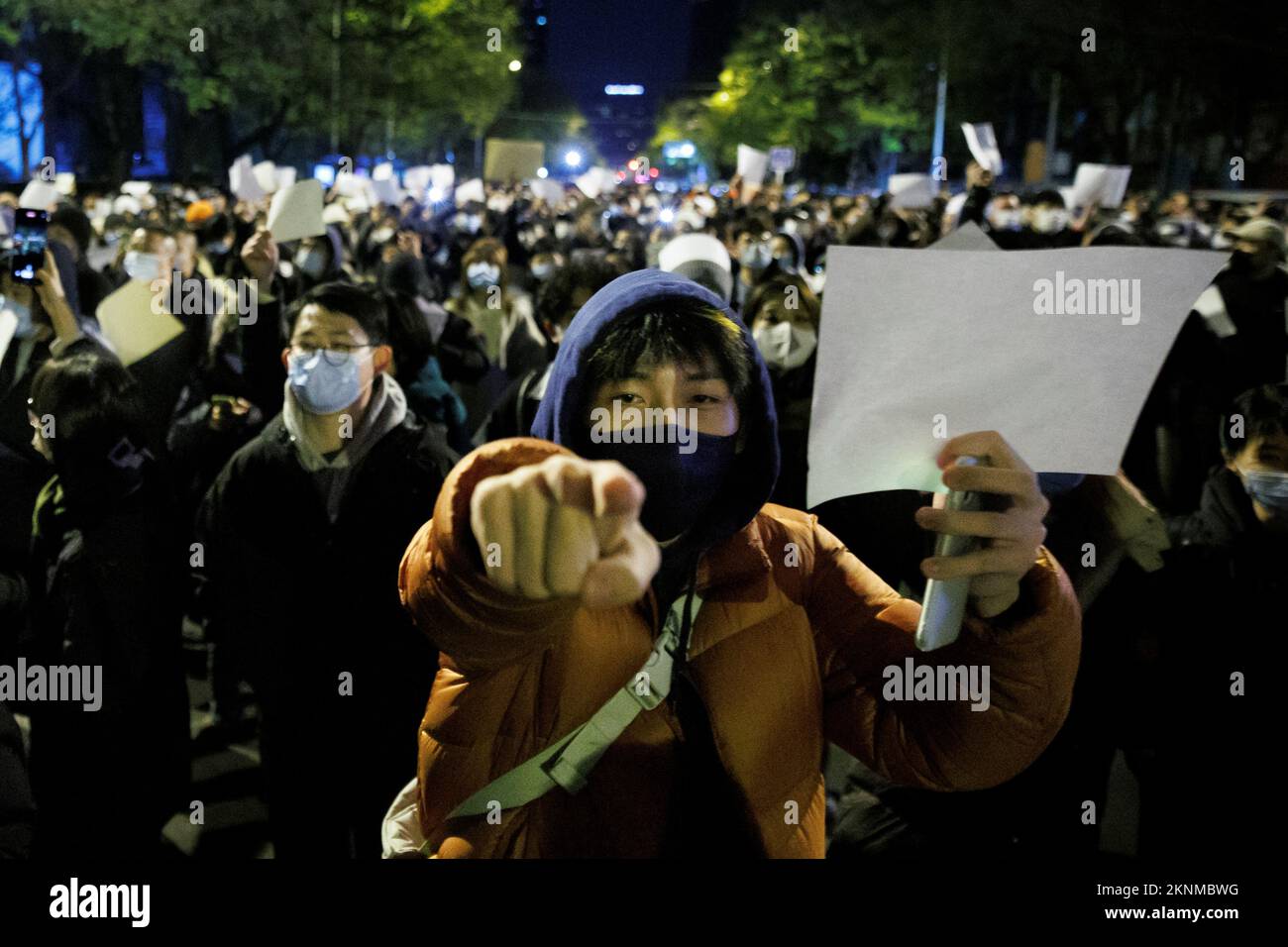 People hold white sheets of paper in protest over coronavirus disease (COVID-19) restrictions, after a vigil for the victims of a fire in Urumqi, as outbreaks of COVID-19 continue, in Beijing, China, November 27, 2022. REUTERS/Thomas Peter Stock Photo