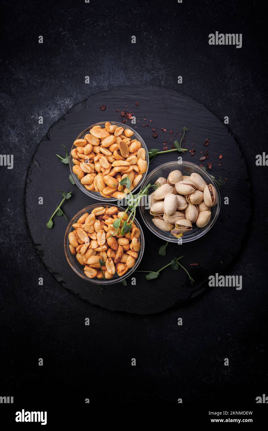 Salted nuts, pistachios and peanuts, for beer, on a dark background Stock Photo