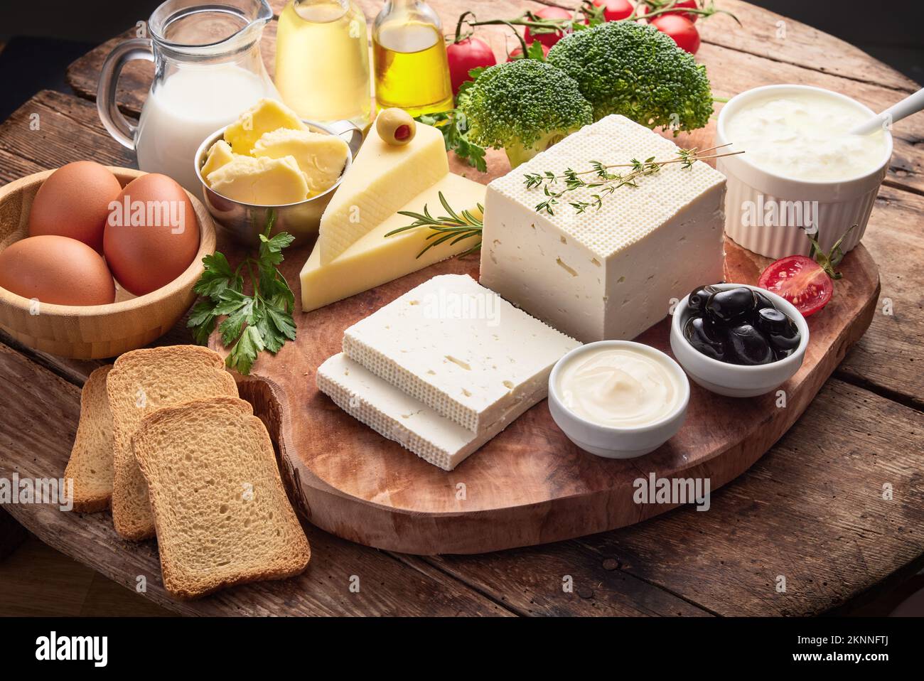 Fresh dairy products isolated on wooden background. Food collage of milk, cheese, butter, egg, vegetables, herbs, bread. Stock Photo