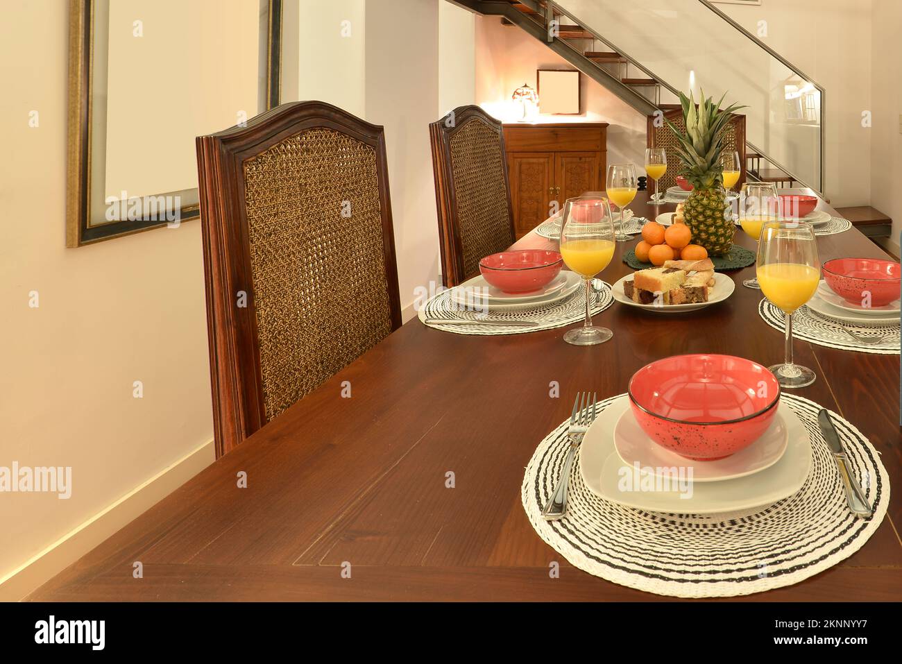 https://c8.alamy.com/comp/2KNNYY7/one-side-of-a-long-mahogany-dining-table-with-mahogany-armchairs-and-a-breakfast-service-of-fruit-and-orange-juice-in-crystal-goblets-2KNNYY7.jpg