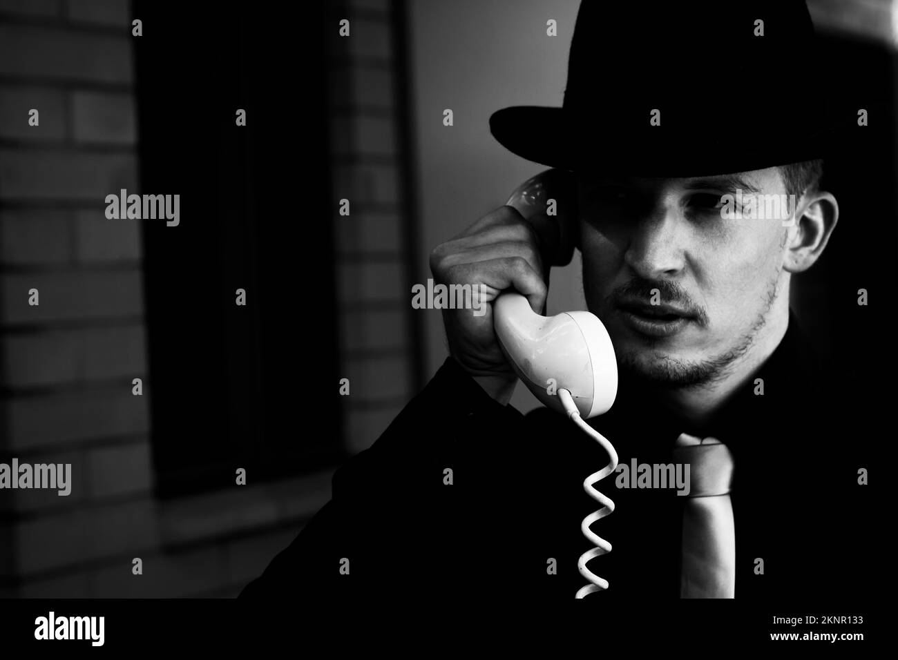 Retro styled fashion portrait of a Film noir detective talking with