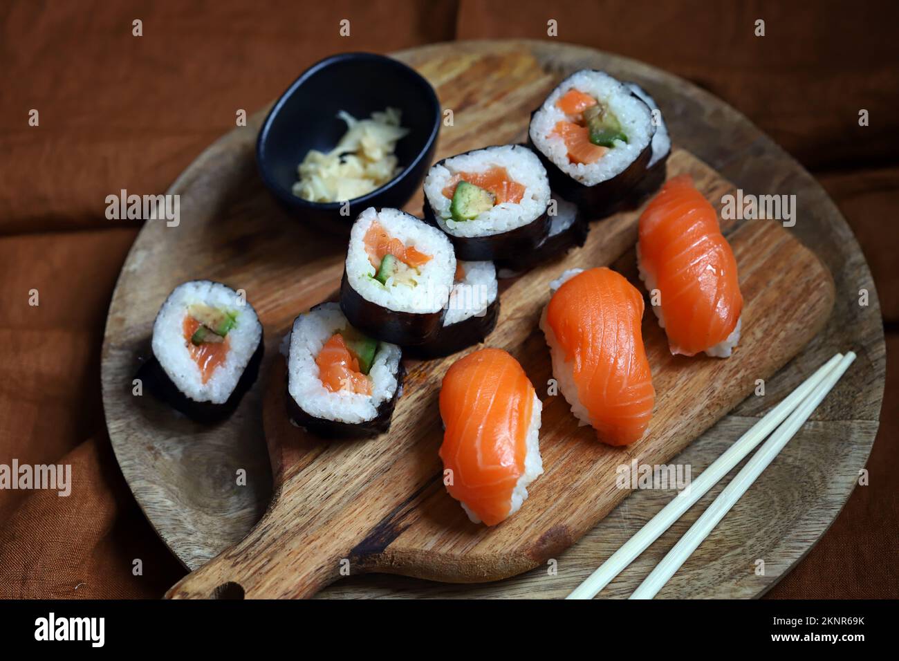 Sushi and rolls with avocado and salmon on a wooden board. Stock Photo
