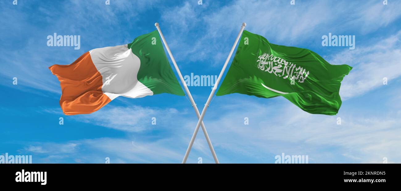 two crossed flags Saudi Arabia and Ireland waving in wind at cloudy sky ...