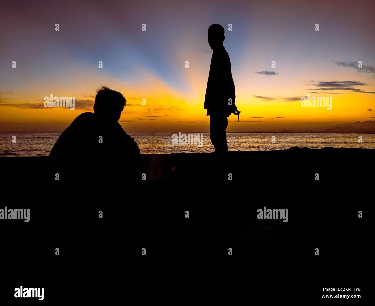 silhouette of people with sunrise on the beach Stock Photo
