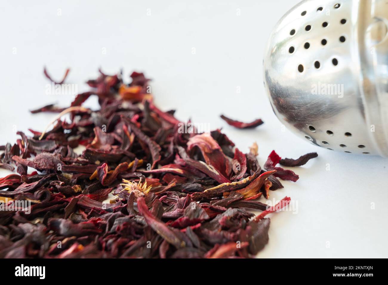 Close up of loose hibiscus tea leaves and tea ball on white background Stock Photo Alamy