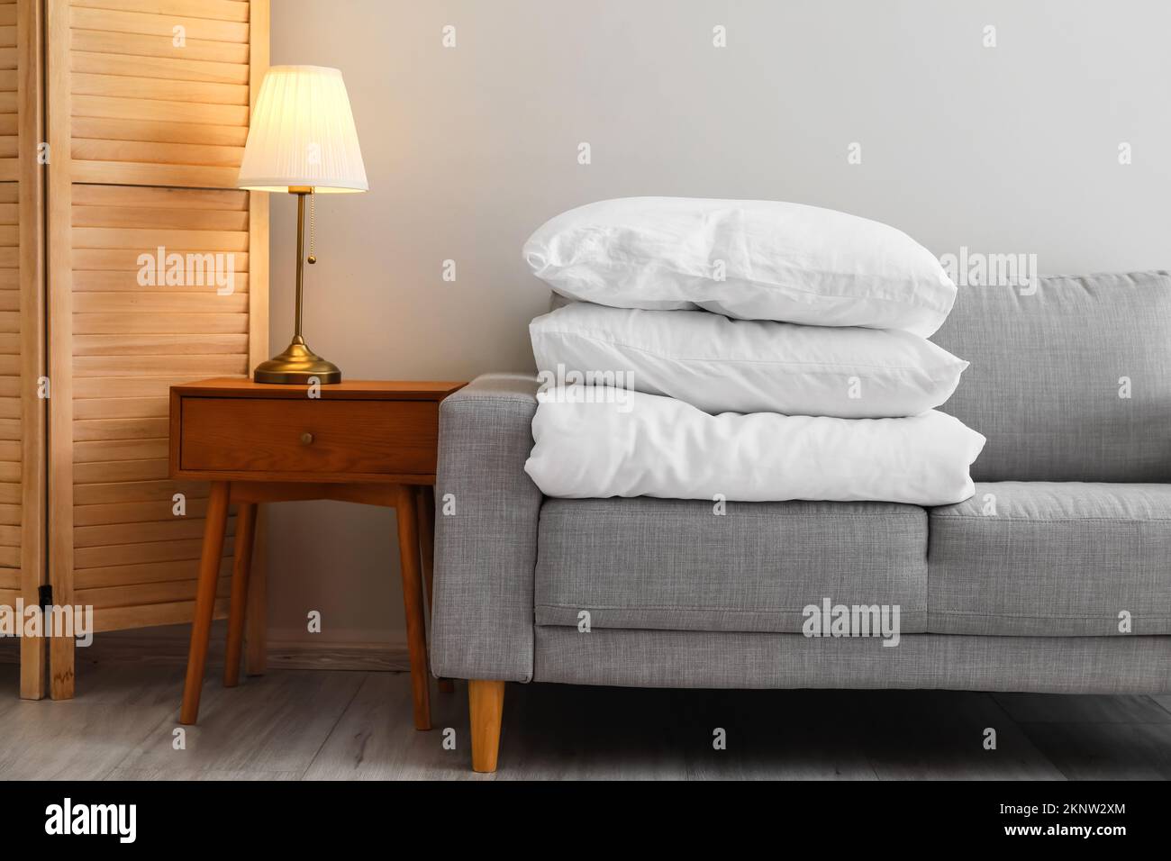 Stack of blanket and pillows on comfortable sofa Stock Photo