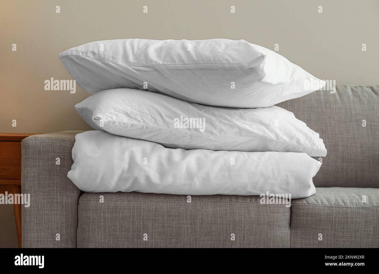 Stack of blanket and pillows on comfortable sofa Stock Photo