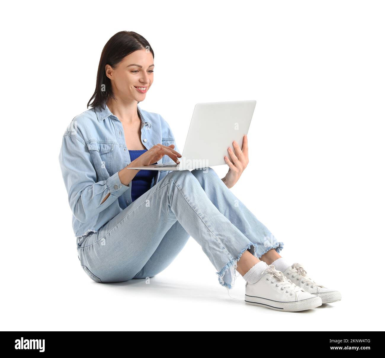 Pretty young woman with laptop sitting against white background Stock ...