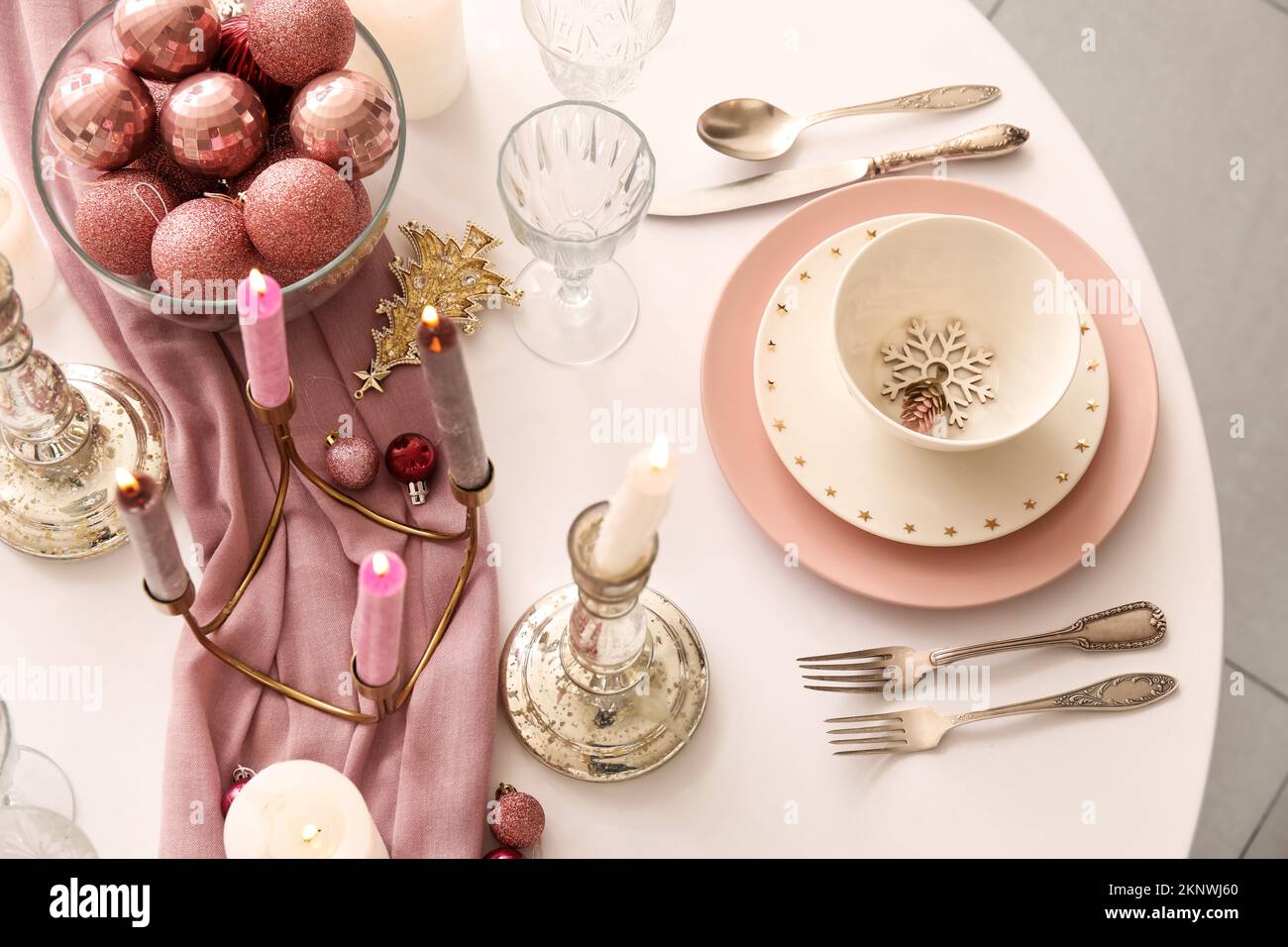 Christmas table setting with burning candles and balls in dining room ...