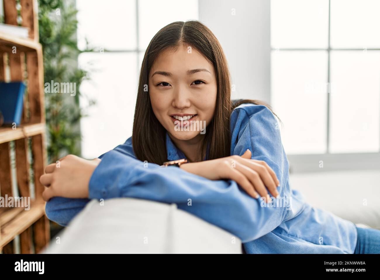 Young chinese girl smiling happy sitting on the sofa at home Stock ...