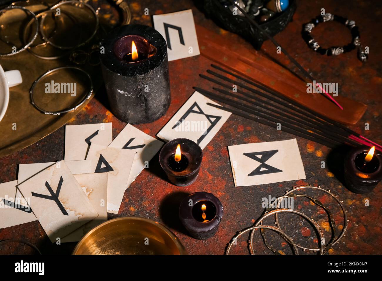 Runes for fortune telling and candles on table Stock Photo - Alamy