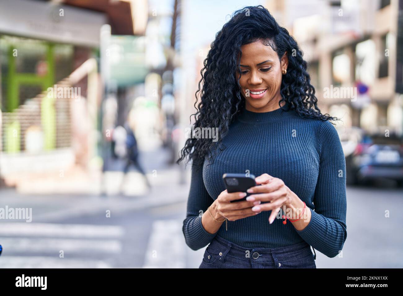 African american woman smiling confident using smartphone at street ...