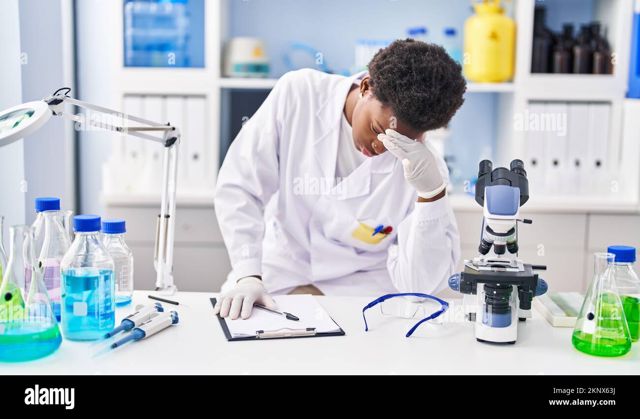 Stressed Lab Tech African american woman wearing scientist uniform stressed working at ...