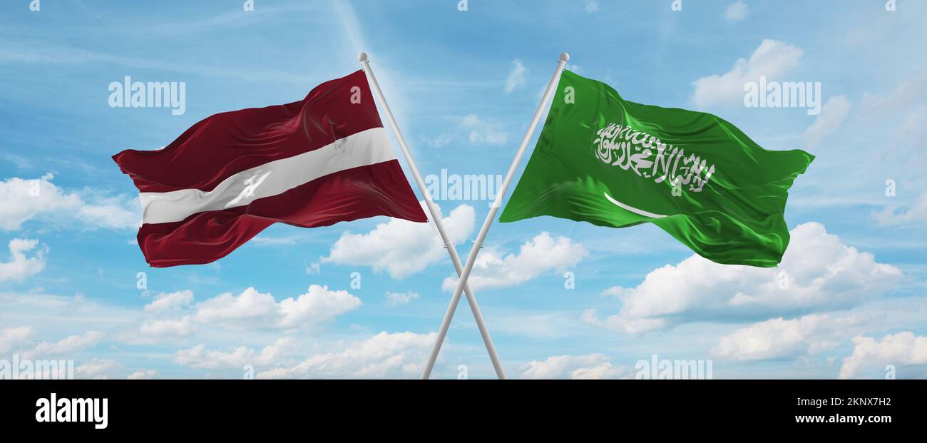 two crossed flags Saudi Arabia and Latvia waving in wind at cloudy sky ...
