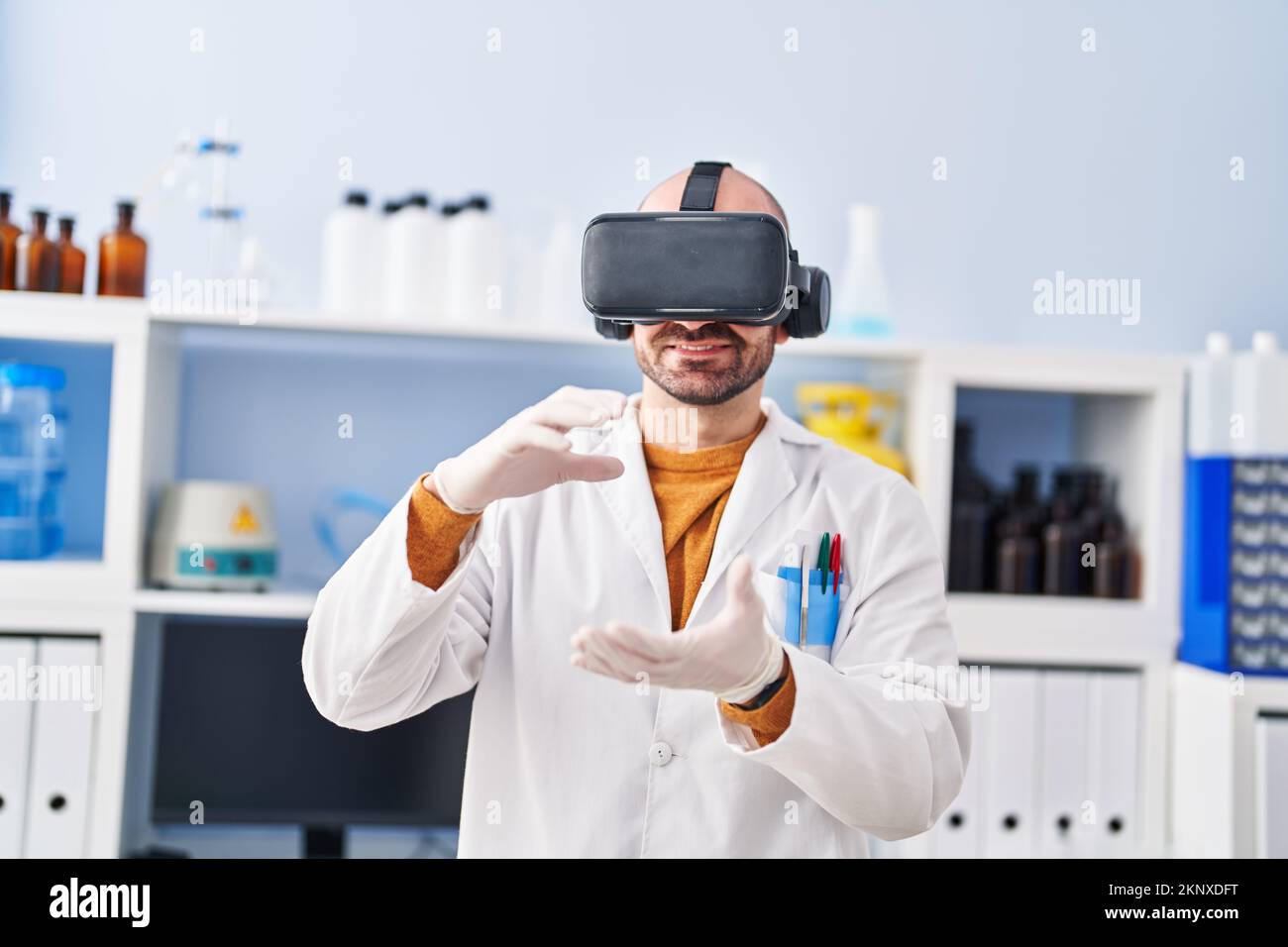 Young man scientist using virtual reality goggles at laboratory Stock Photo