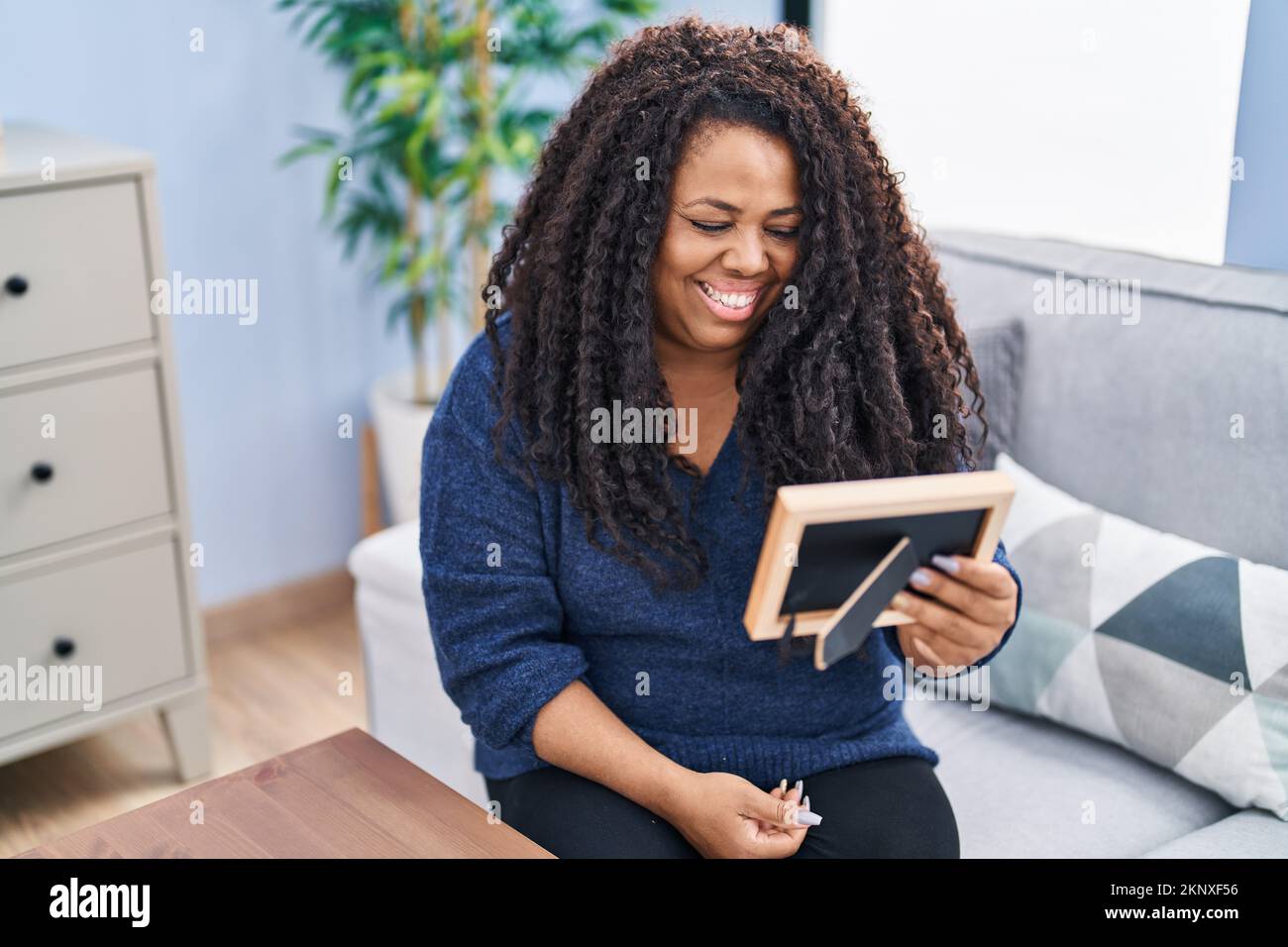 African american woman looking picture sitting on sofa at home Stock ...