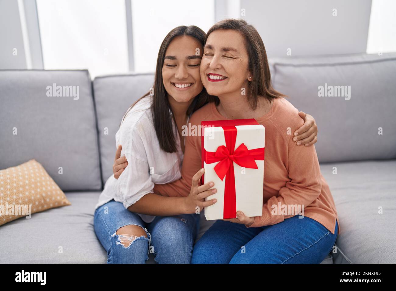 Two women mother and daughter surprise with gift at home Stock Photo — free download