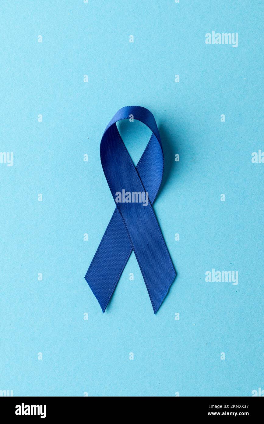 Vertical of blue ribbon for prostate cancer awareness, on blue