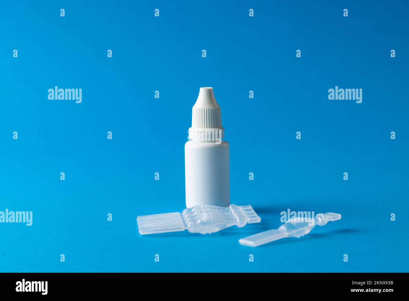 Composition of saline solution caplets and dropper bottle on blue background with copy space Stock Photo
