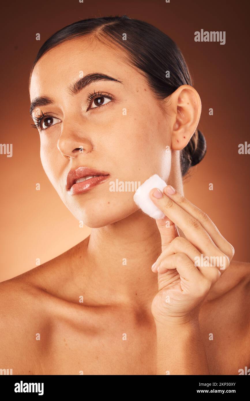 Woman, skincare beauty and cotton for face, health and cleaning for cosmetic glow by brown studio backdrop. Model, cottonwool and skin with Stock Photo