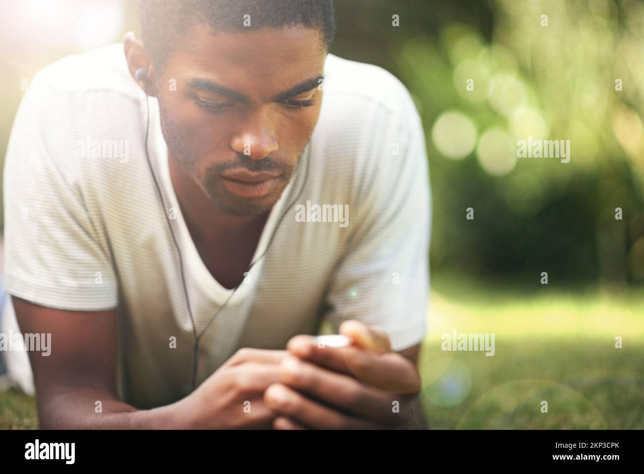 When words fail, music speaks. a young man listening to music outdoors ...