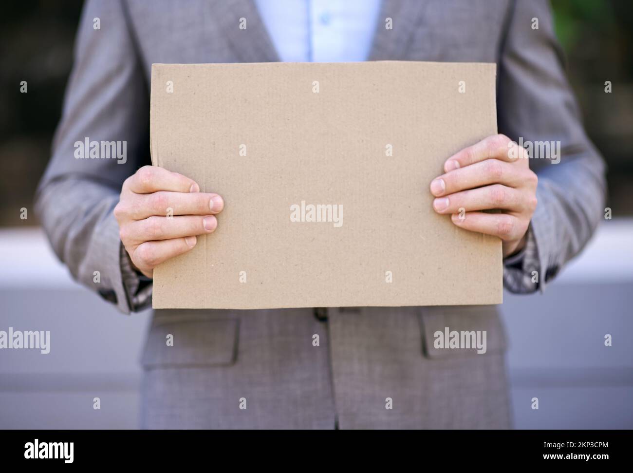 Will give financial advice for food. a businessman holding a blank placard in the street. Stock Photo