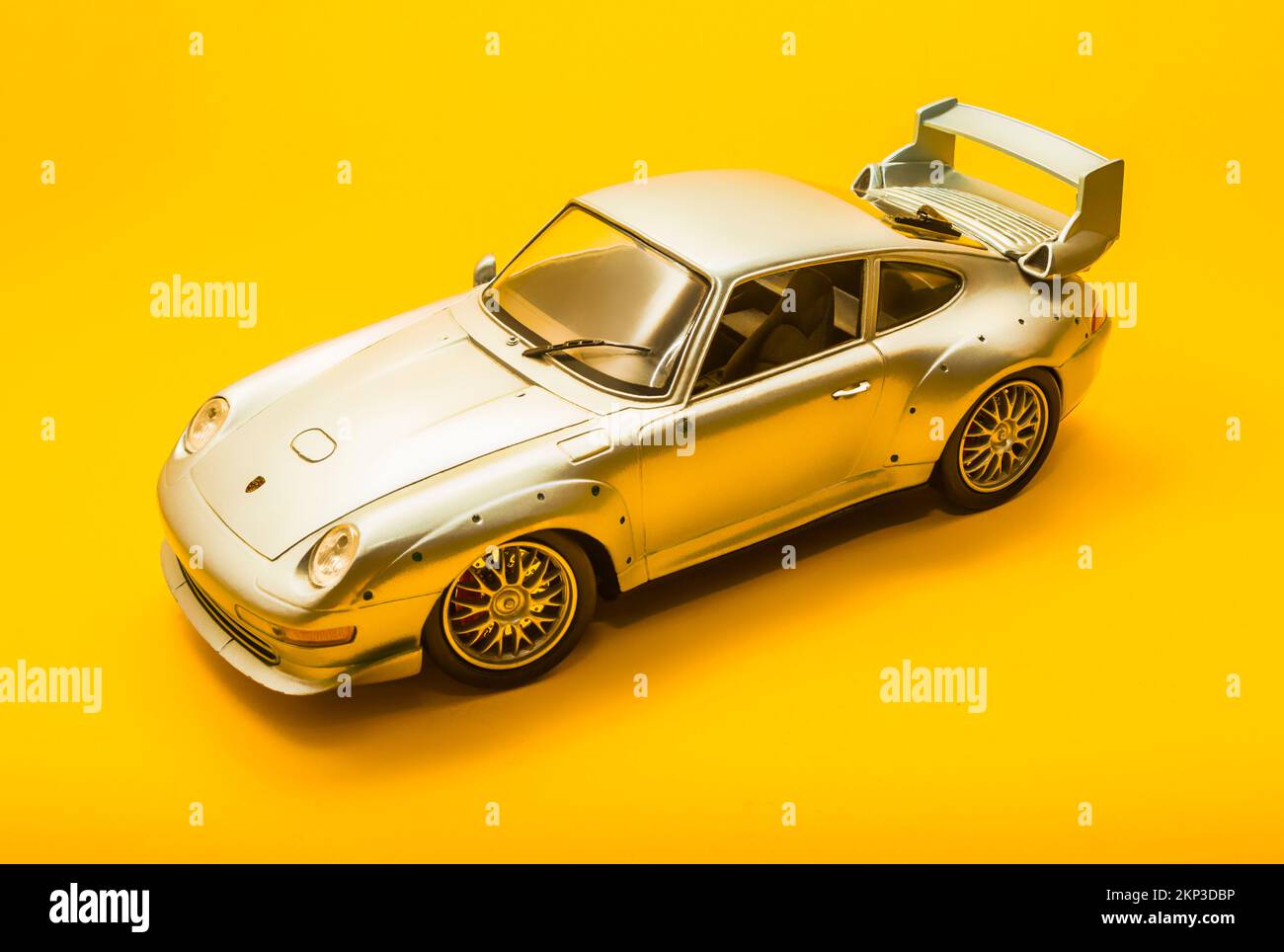 Model car design on a silver Porsche 911 GT2 on bright yellow studio background Stock Photo