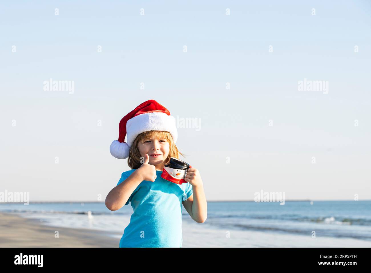 Christmas kids. Litte Santa on the sunset sea. Summer New Year. Winter  beach, concept for travel in hot countries Stock Photo - Alamy