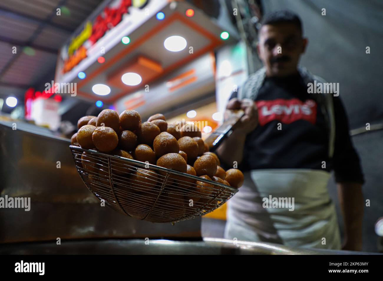 Gaza City, Gaza City. 27th Nov, 2022. A vendor makes Luqmat al-Qadi sweets, a traditional pastry made of leavened and deep fried dough, at a market in Gaza City, Nov. 27, 2022. Credit: Rizek Abdeljawad/Xinhua/Alamy Live News Stock Photo