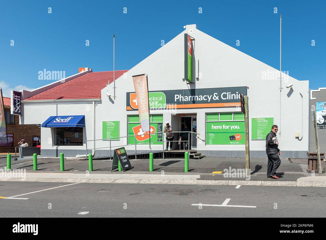 Kleinmond, South Africa - Sep 20, 2022: A street scene, with a pharmacy, clinic and people, in Kleinmond in the Western Cape Province Stock Photo