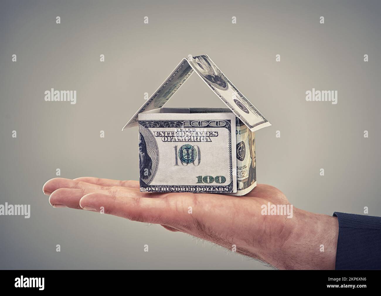 He can buy his dream home now. Close up conceptual shot of a man holding money that has been made to look like a house. Stock Photo